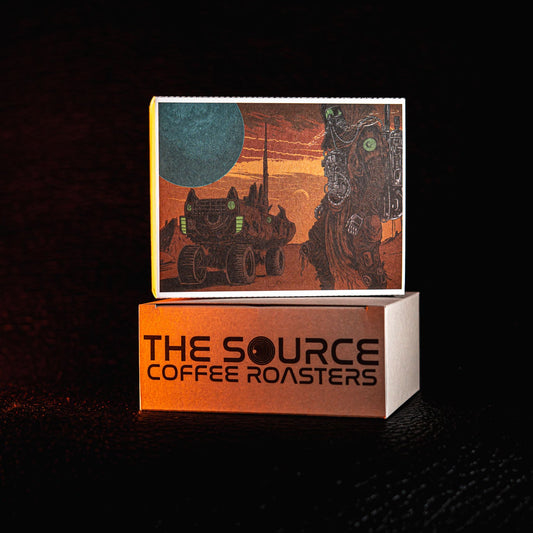 Box with 'The Source Coffee Roasters' branding on a dark background
